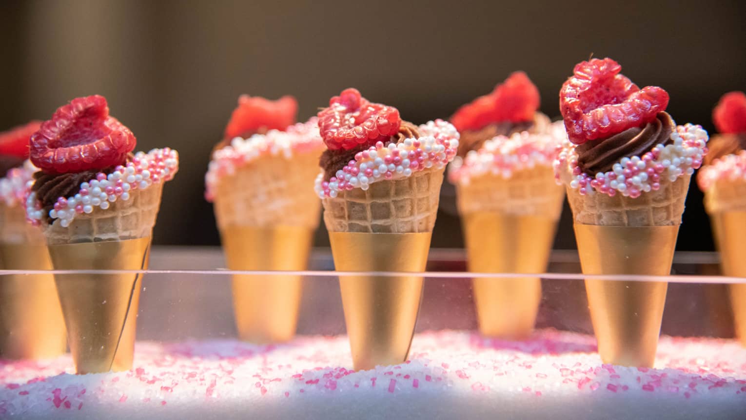 Miniature waffle cone display, with sprinkles and raspberry topping
