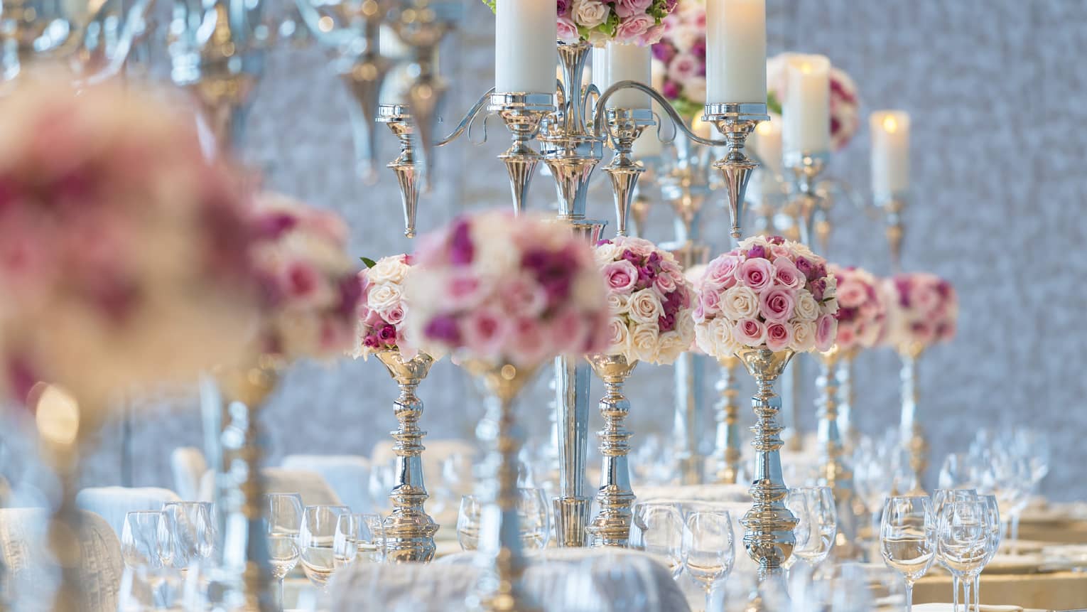 Peony Ballroom banquet table with rows of tall candles, pink roses