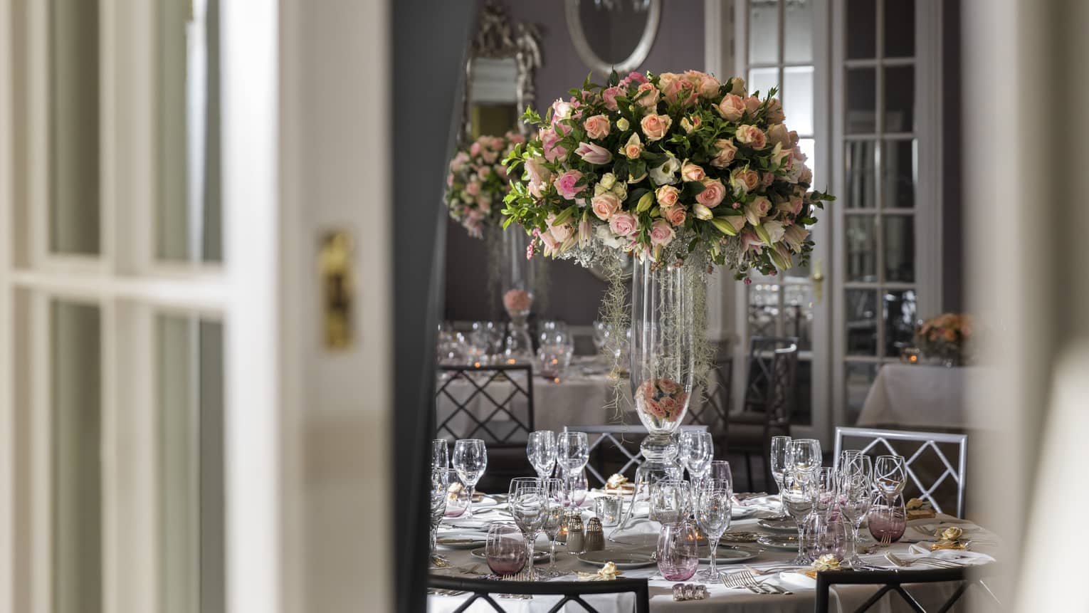 Arcadia Ballroom view through French doors to tall floral centrepiece on dining table with glassware
