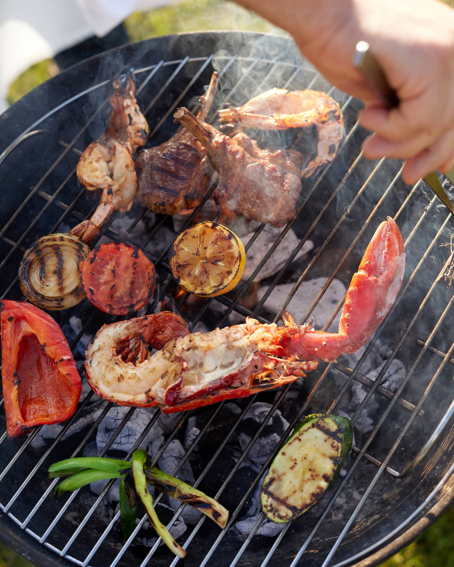 Seafood, lamb and vegetables cooking on a charcoal grill