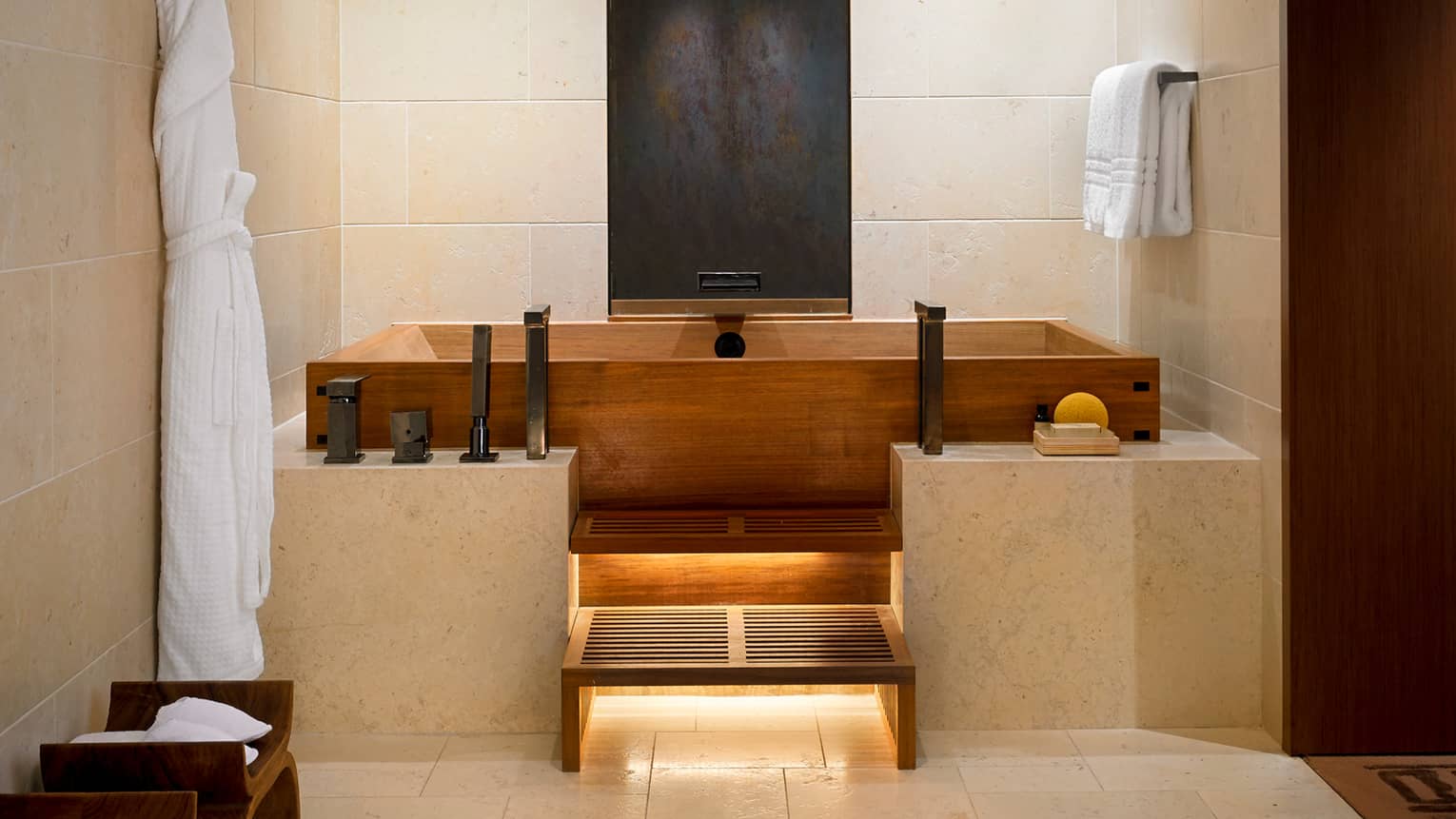 Alii Royal Suite master bathroom with modern wood Japanese soaking tub, marble ledge, tile walls
