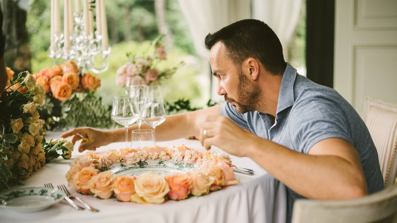 Artistic Director Vincenzo Dascanio carefully arranges roses on wedding dining table