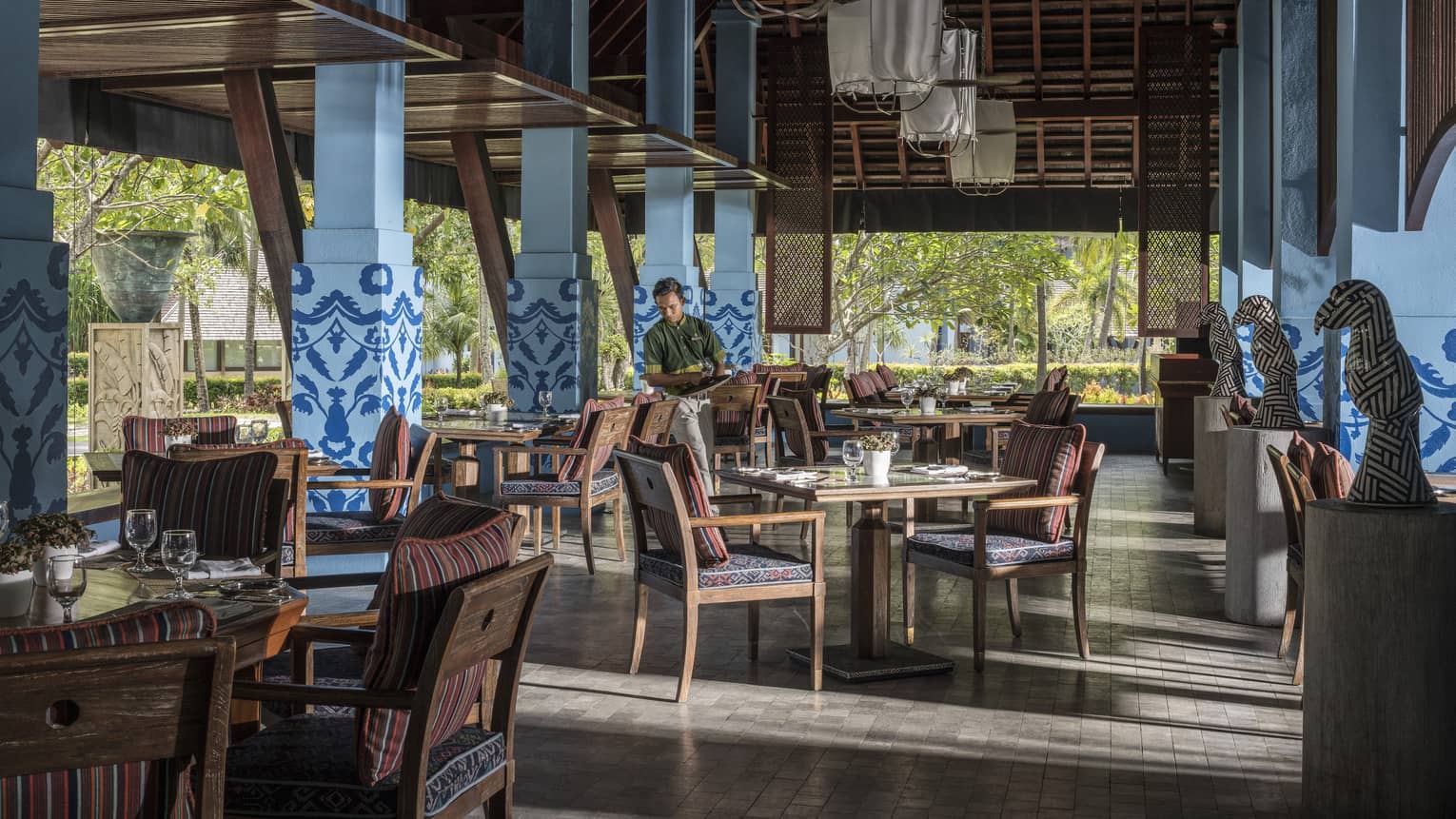 A server in Lower Serai restaurant Dining room sets the table