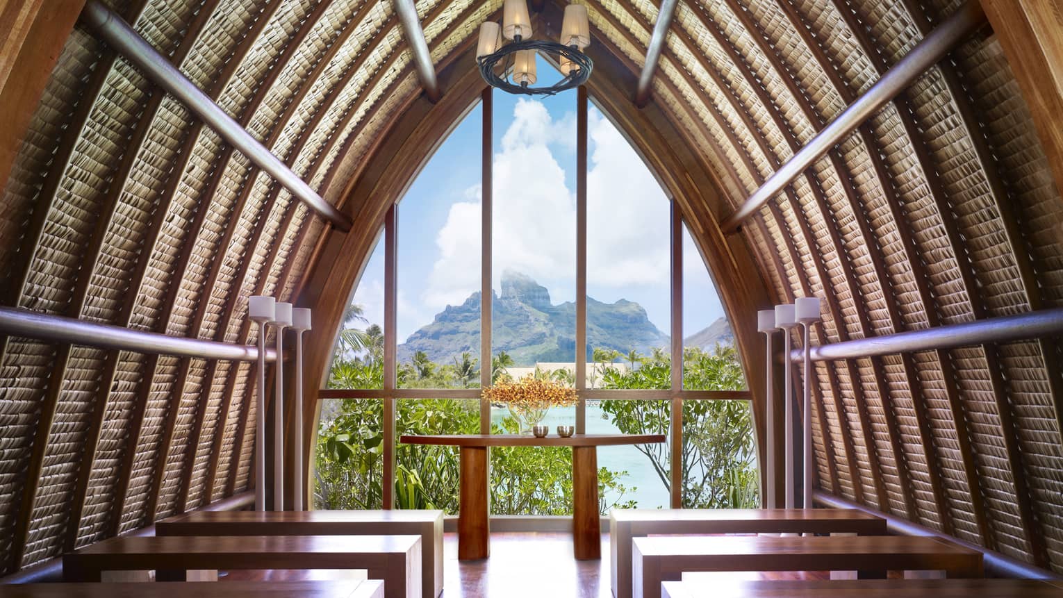 Arched roof of Aherenona chapel with end window looking over resort, lagoon and mountain