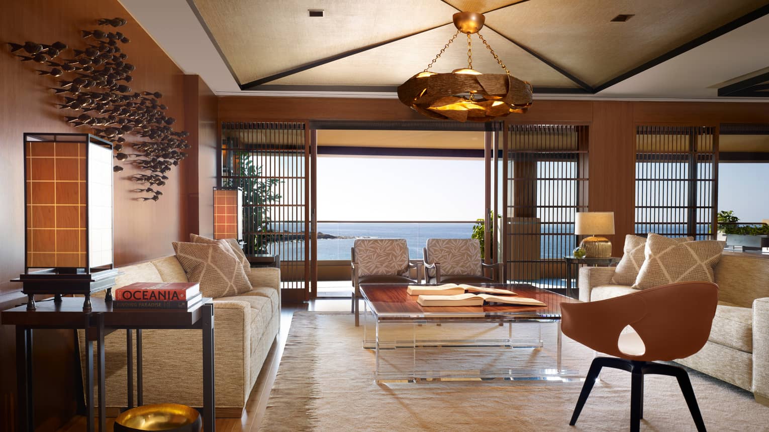 Alii Royal Suite spacious seating area with bespoke furnishings, mid-century style sofas, chairs, light