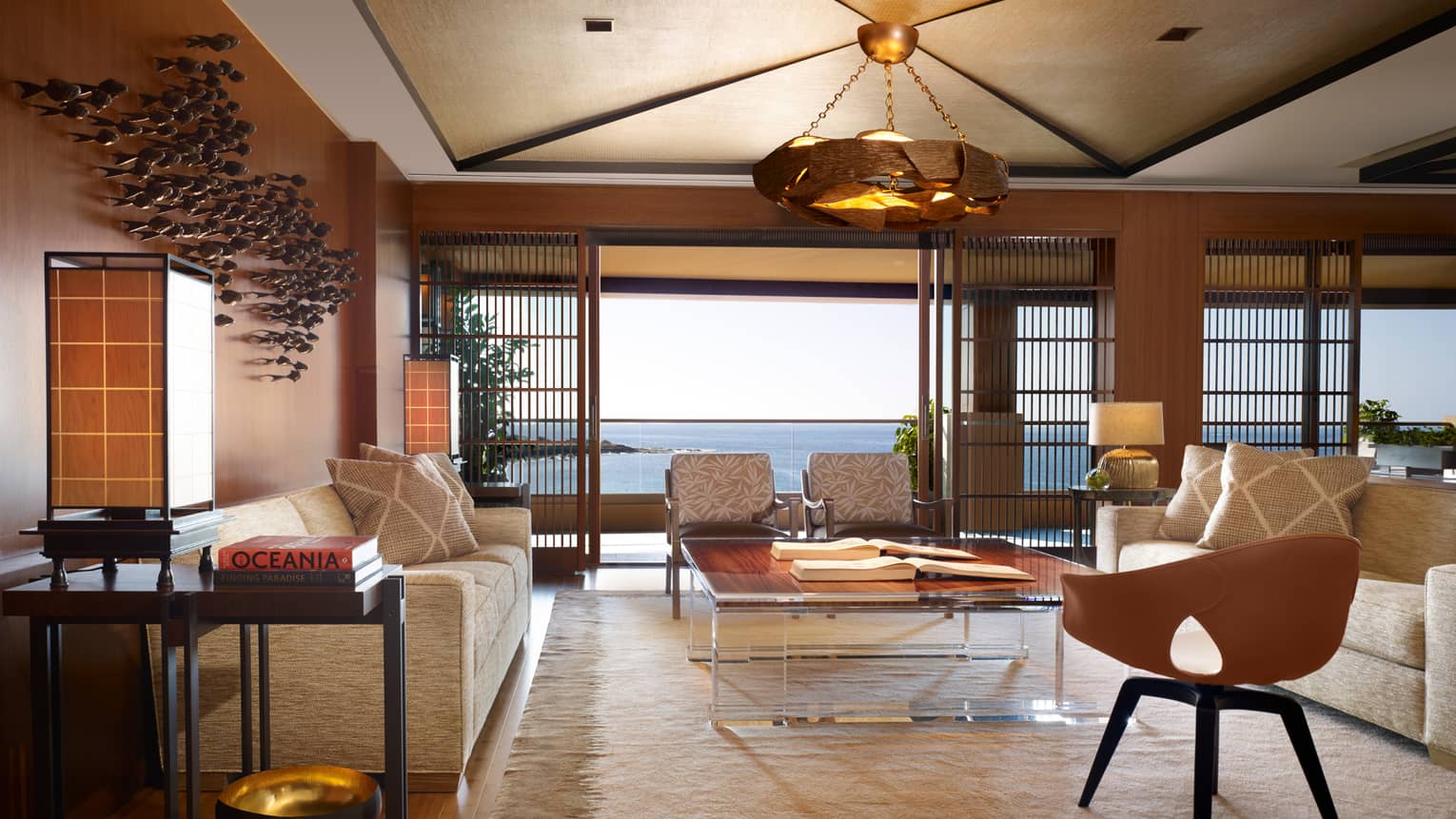 Alii Royal Suite spacious seating area with bespoke furnishings, mid-century style sofas, chairs, light