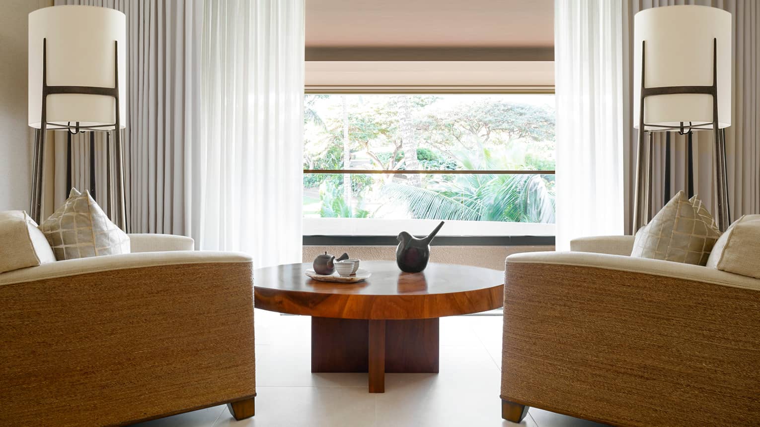 Large armchairs around wood table, sunny window in Couples Suite