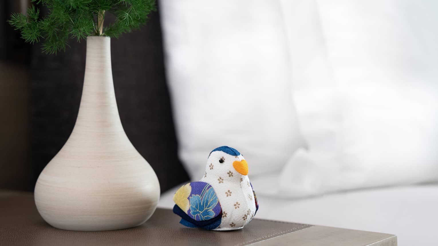 Four Seasons Hotel Tokyo at Otemachi colourful duck doll sits on wooden night stand next to vase of green plant