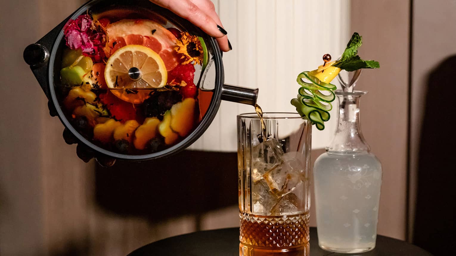 Pimm’s Cup signature drink at Bandista, fruit-infused cocktail being poured into tall glass