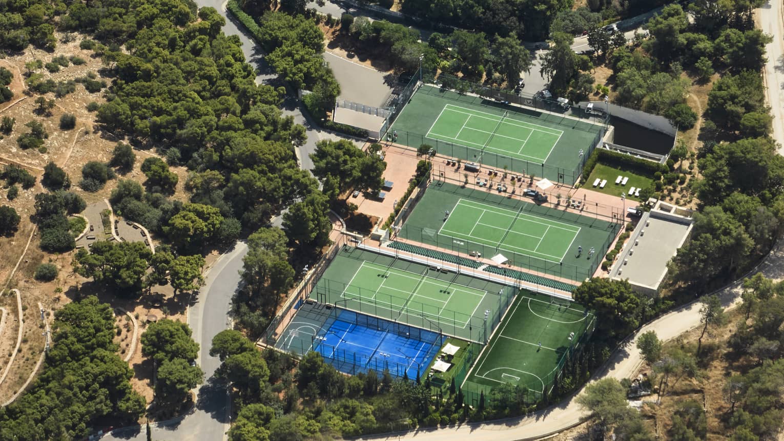 Aerial view of one padel and three tennis courts