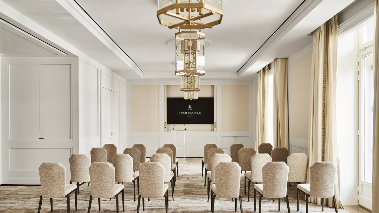 Classroom-style meeting room setup with TV screen at the front of the room.