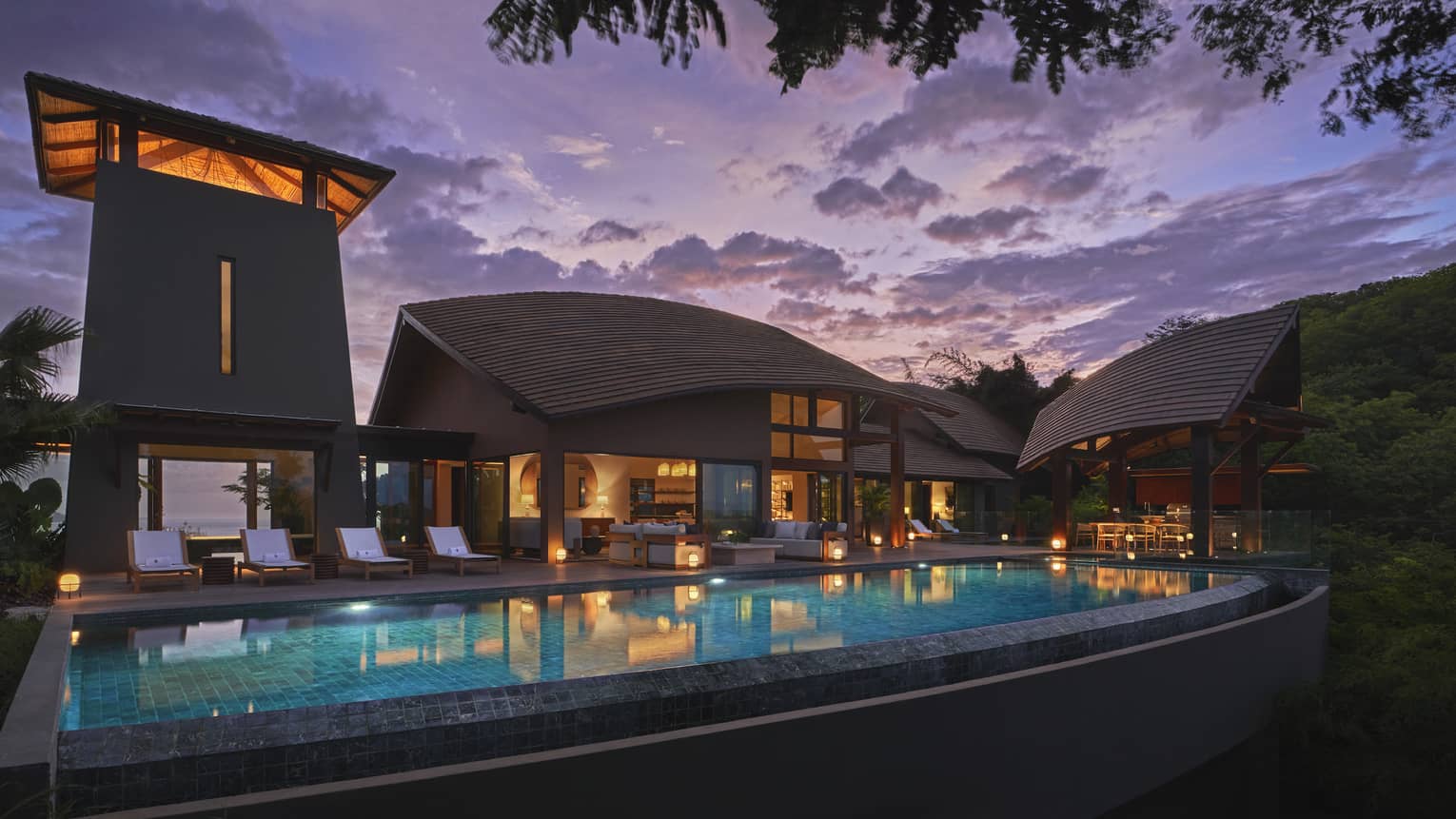 Private villa and pool illuminated at night