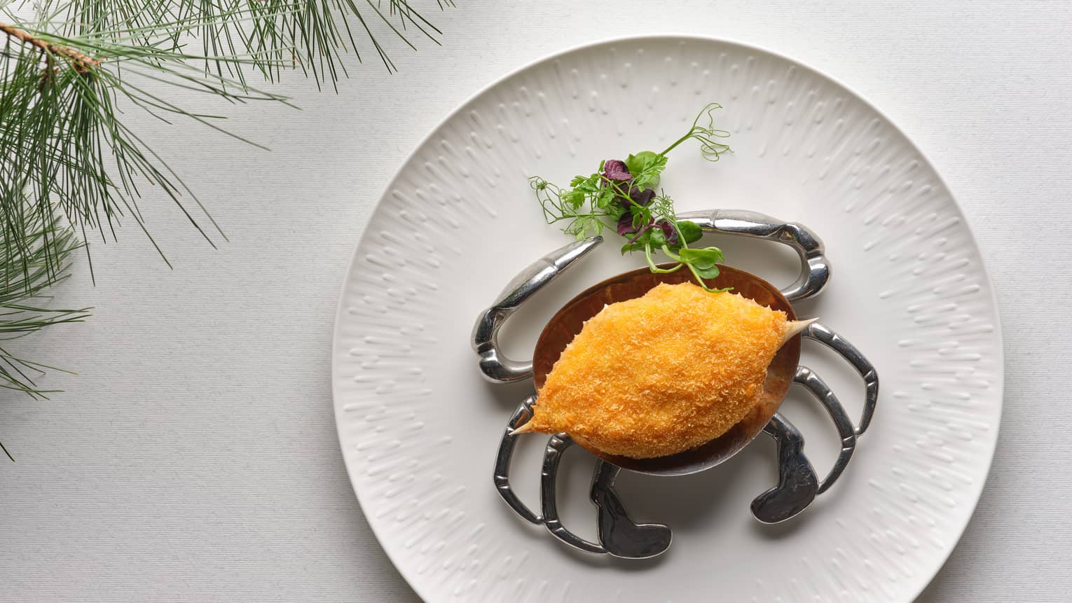 Deep-fried Crab Shell on round white plate with microgreen garnish