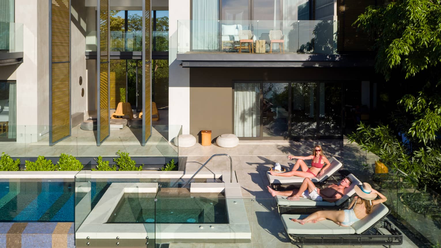 People on lounge chairs by outdoor pool