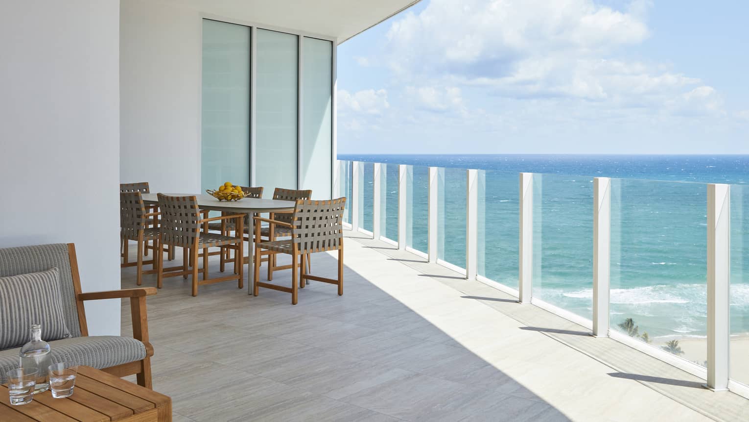 Glass railing balcony with dining table, ocean view