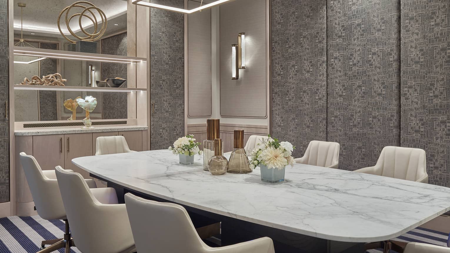 Turay room with marbled conference table, seven white leather chairs, mirrored armoire