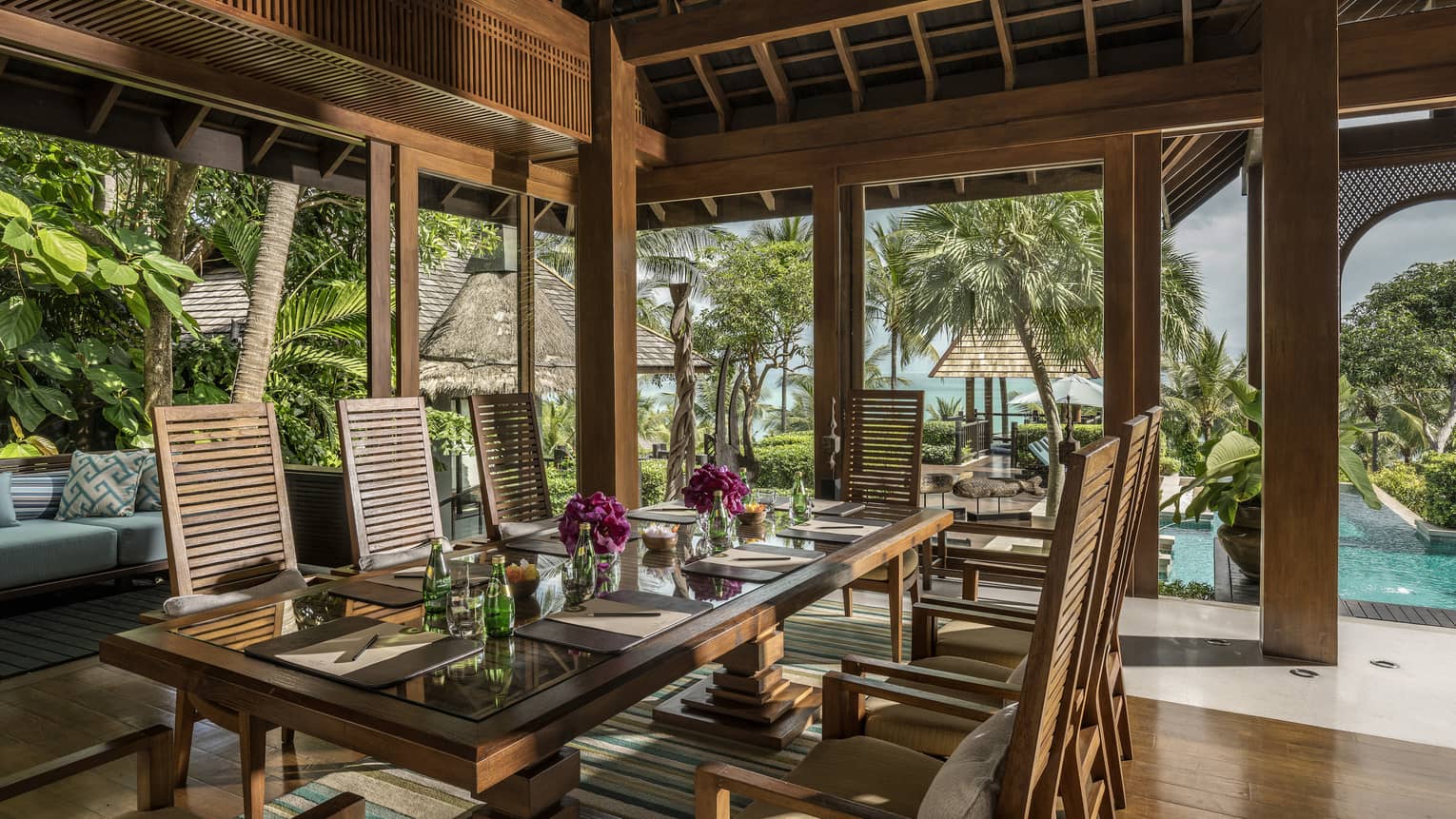 Long wood outdoor dining room, table with purple flowers and sparkling water, menus at each place