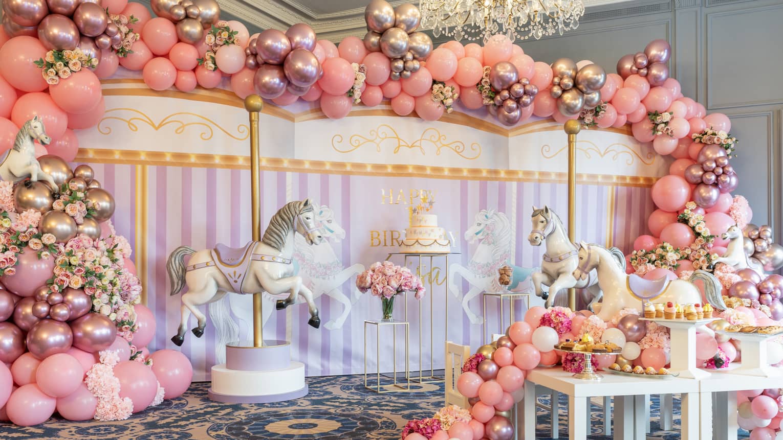 Pink carousel themed decorations fill an event space