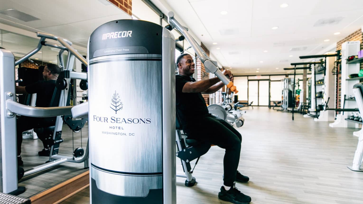 A man uses an arm press at the Four Seasons gym