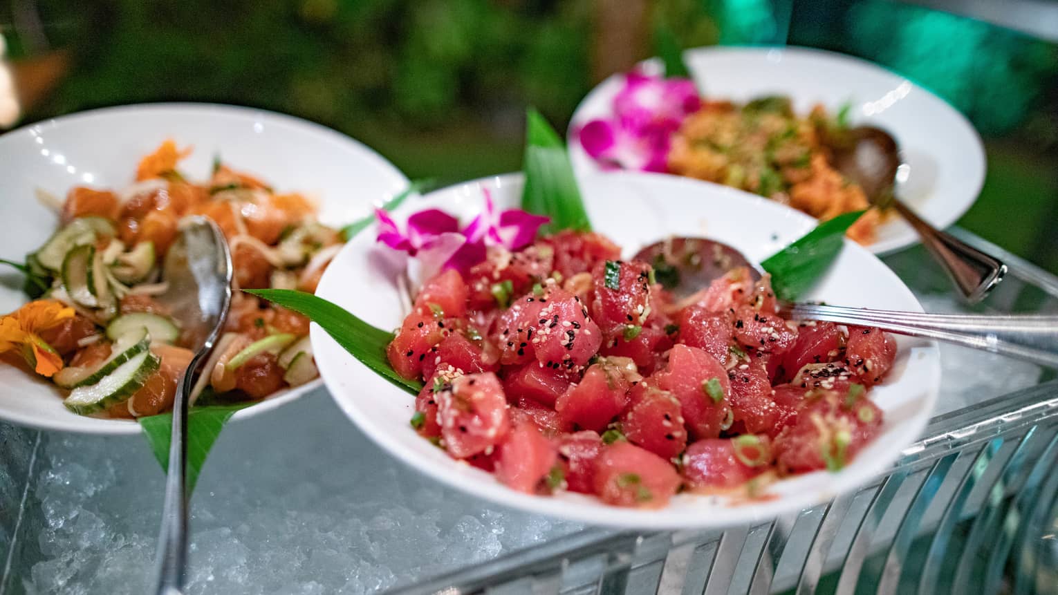 Food buffet with chopped fish and watermelon salads in bowls over ice 