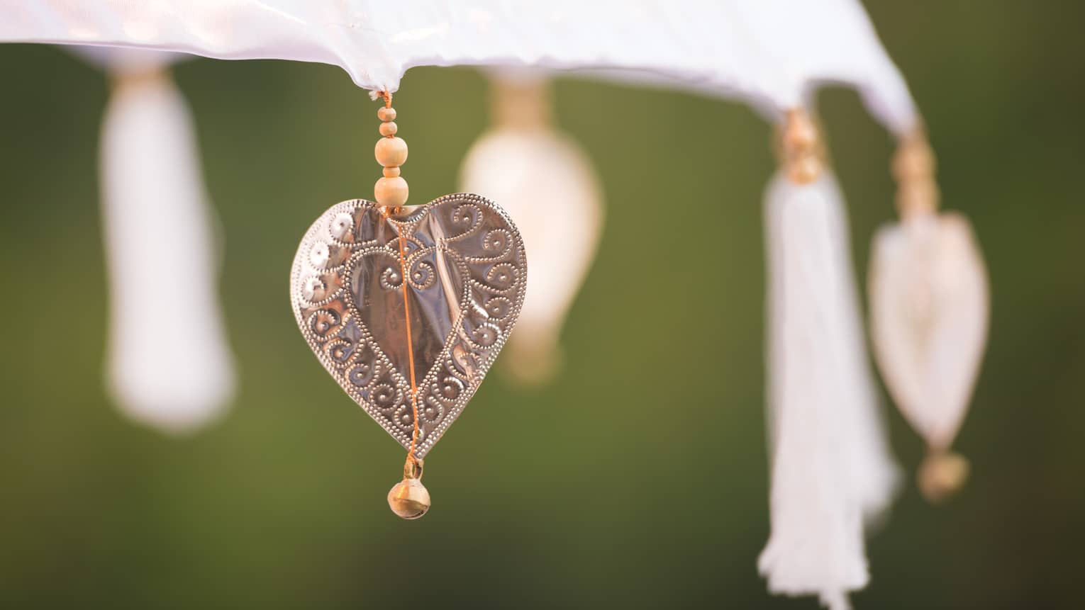Close up of heart shaped charm, tassels