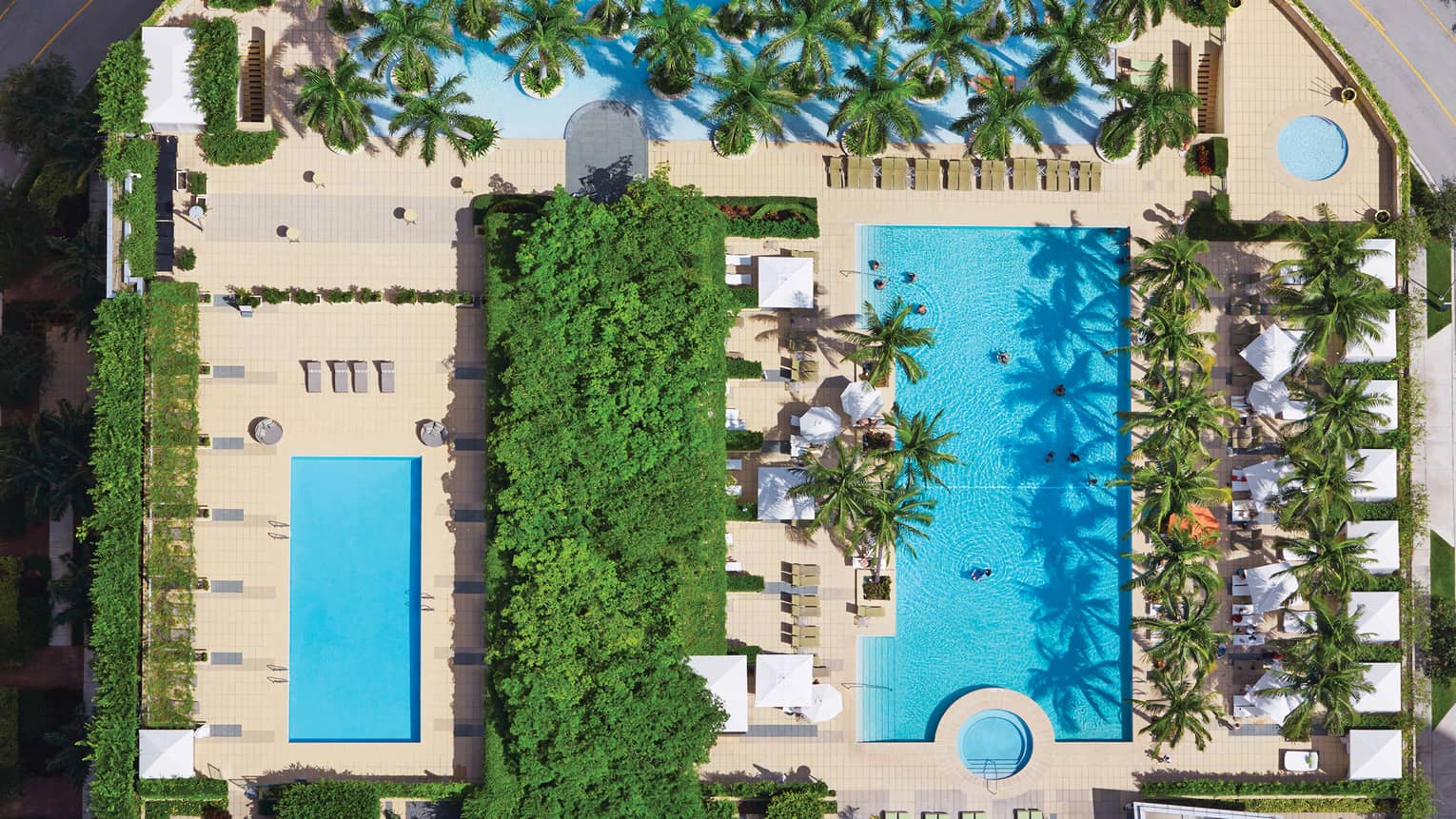 Aerial view of blue outdoor swimming pools, trees 