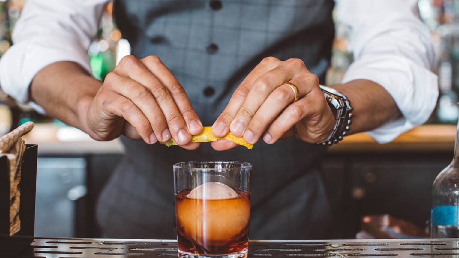 A bartender garnishing a cocktail.