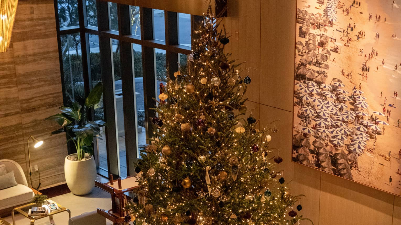 A Christmas tree in the middle of a lobby area.