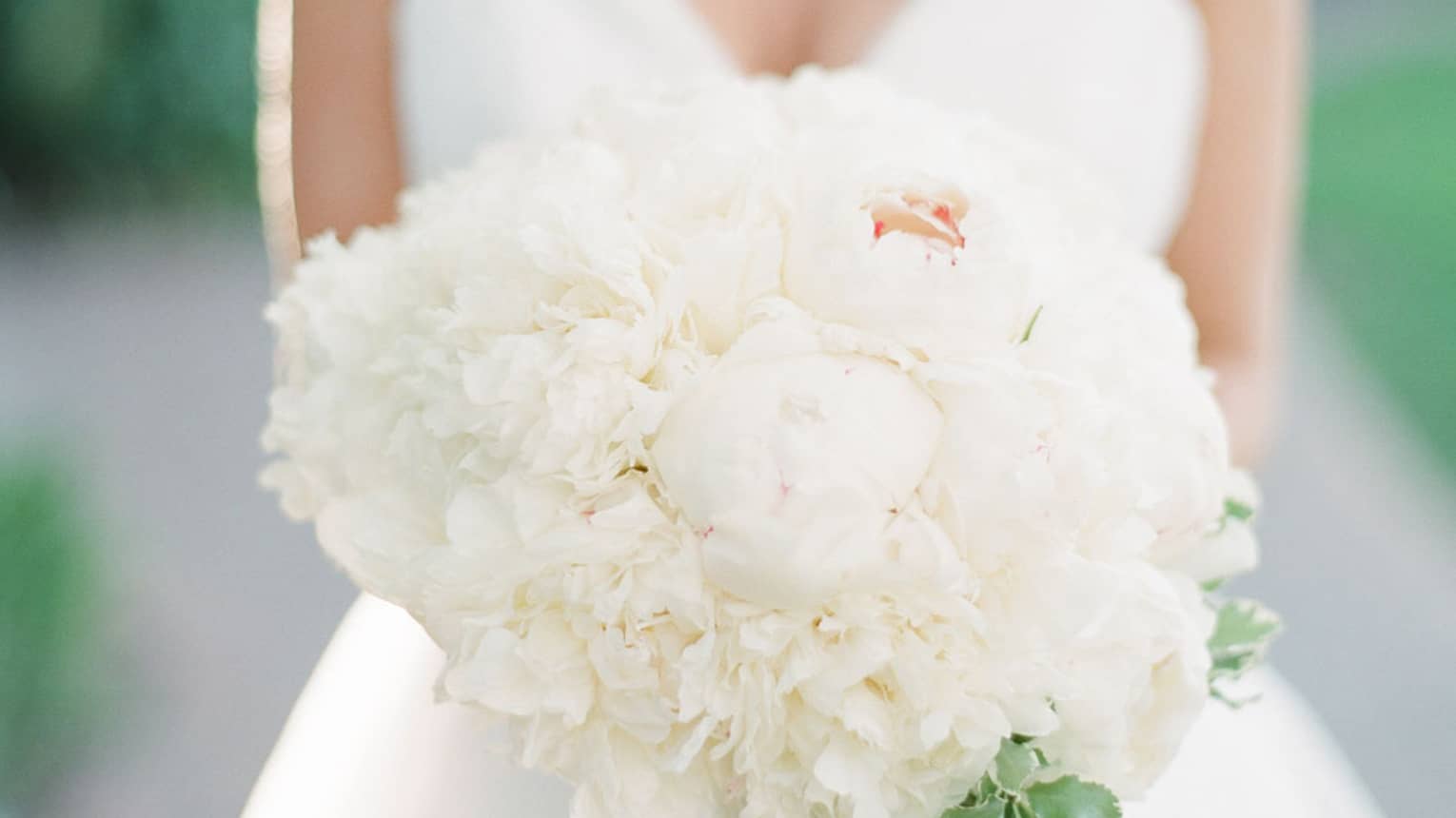Bride holds white floral wedding bouquet
