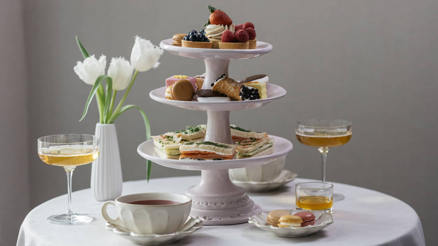 Afternoon tea setting, three-tiered dessert tray, tulips in vase, martinis and tea cups