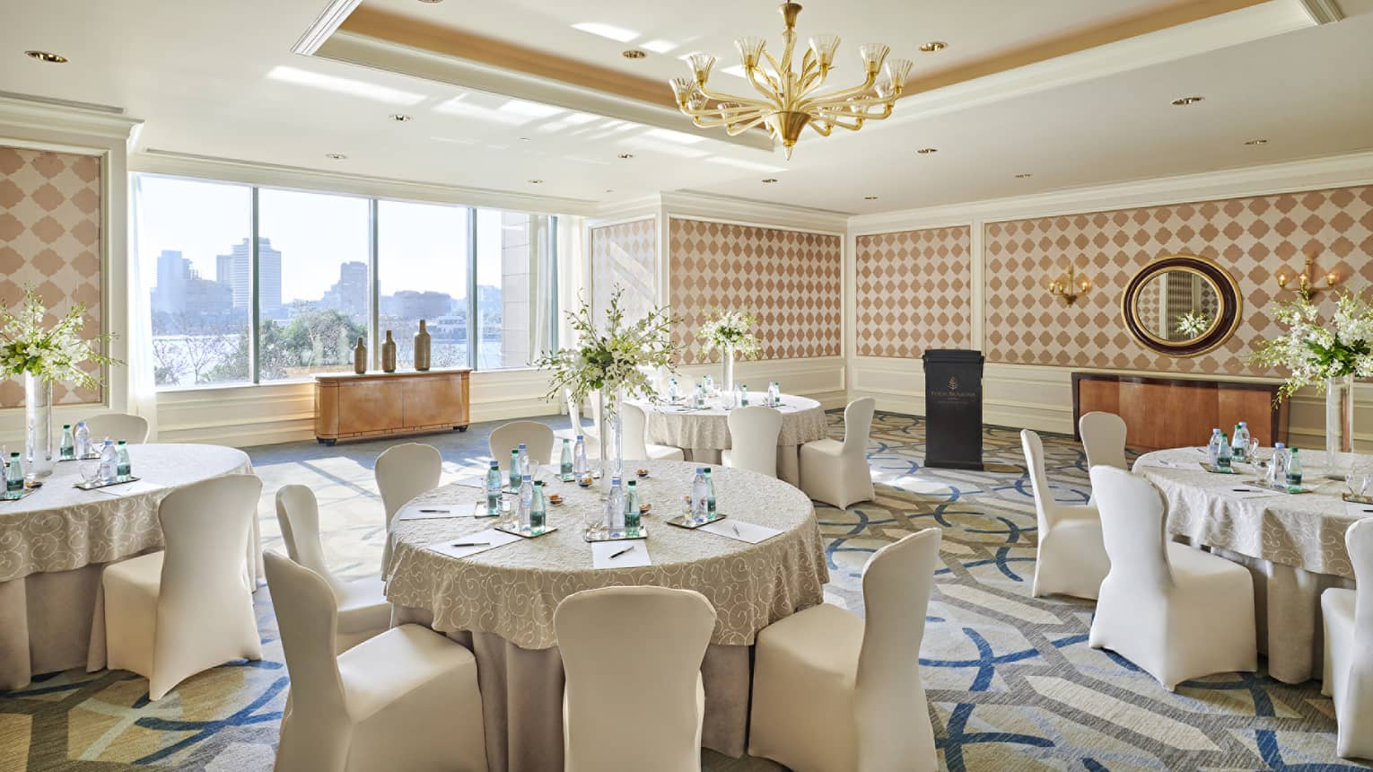 Round banquet tables, linen-covered chairs in sunny Kasr El Nile meeting room