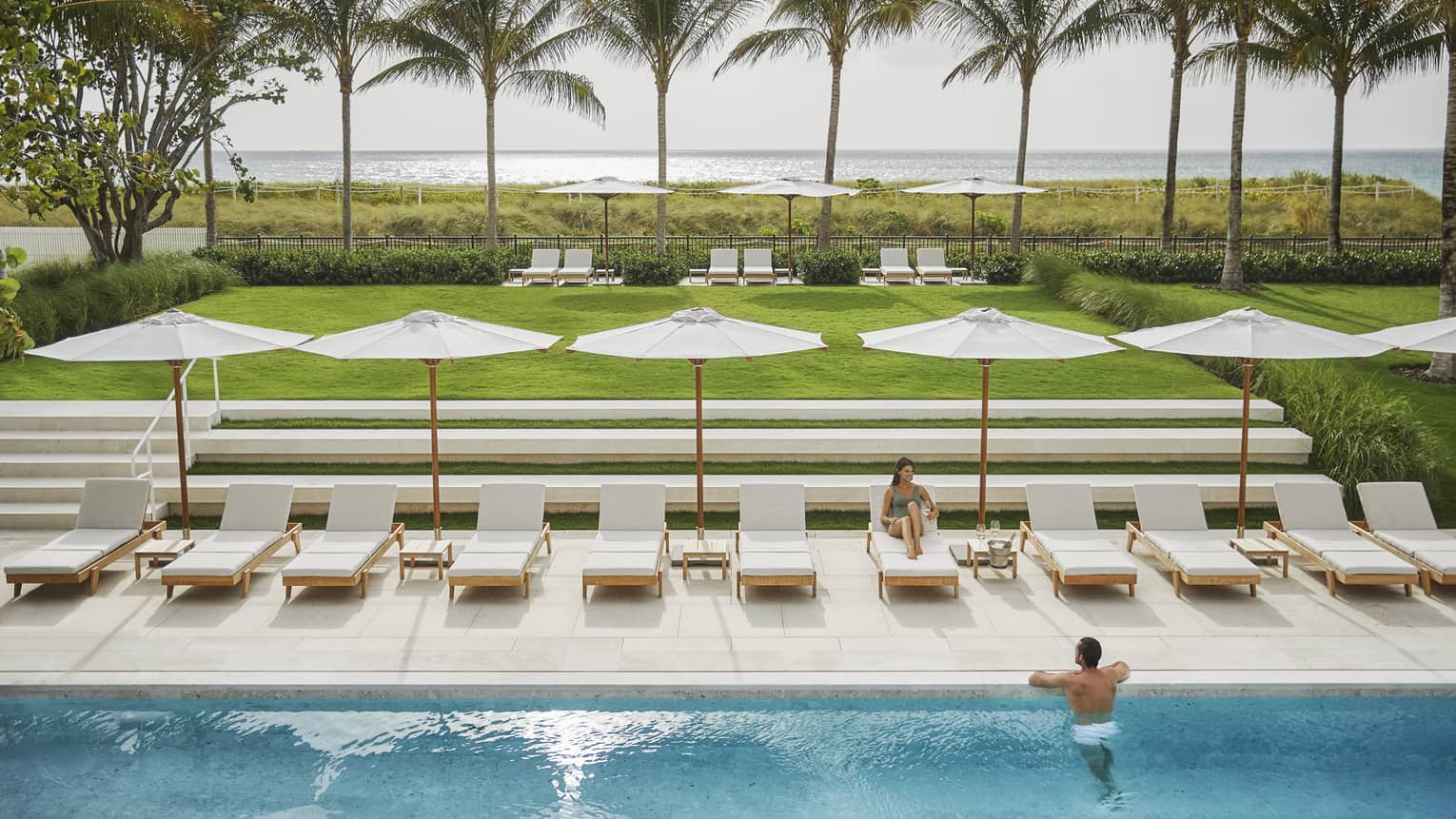 Bird’s eye view of couple enjoying oceanside outdoor pool