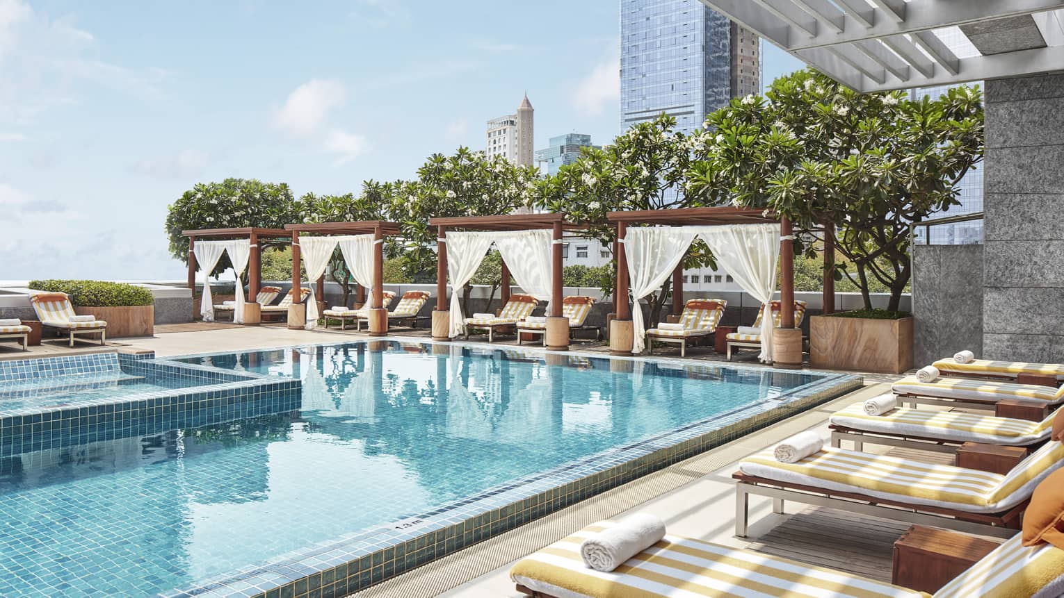 Shaded lounge chairs face the rooftop pool