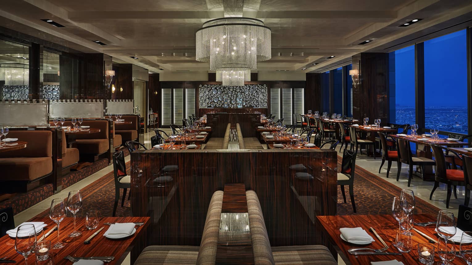 Dining room re Asian Cuisine restaurant with dark wood decor, large chandelier