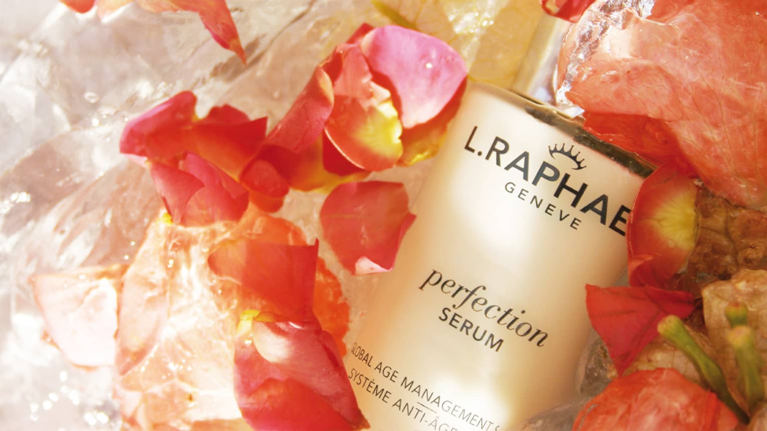 Close-up of bottle of L.RAPHAEL facial serum surrounded by fresh pink flower petals
