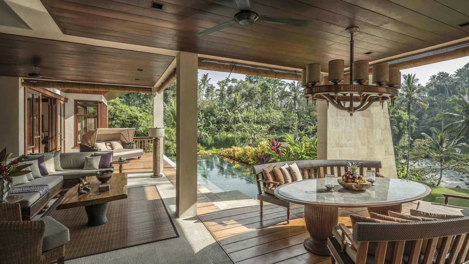 A villa with an outdoor patio and an infinity pool overlooking a river in Bali