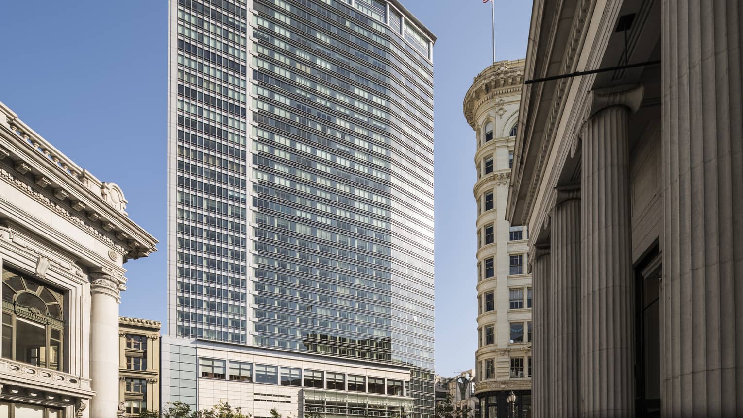 Four Seasons Hotel San Francisco glass high rise building exterior against blue sky 
