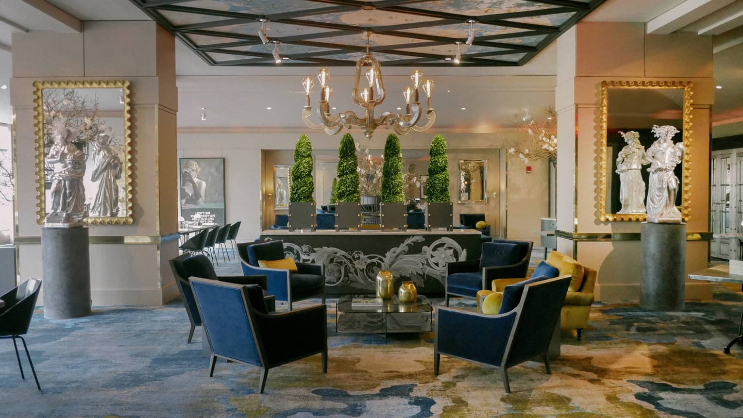 The interior of a restaurant with chairs around a small table, small statues and a hanging chandelier.