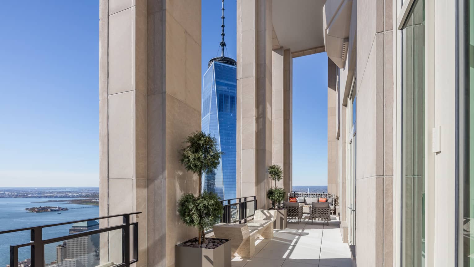 Private penthouse terrace with bench, seating area under soaring stone pillars, Hudson River views