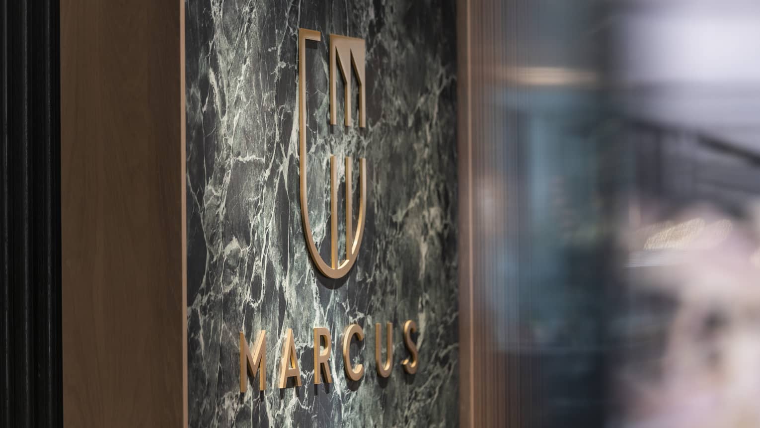 MARCUS Restaurant sign with gold letters on marble wall panel