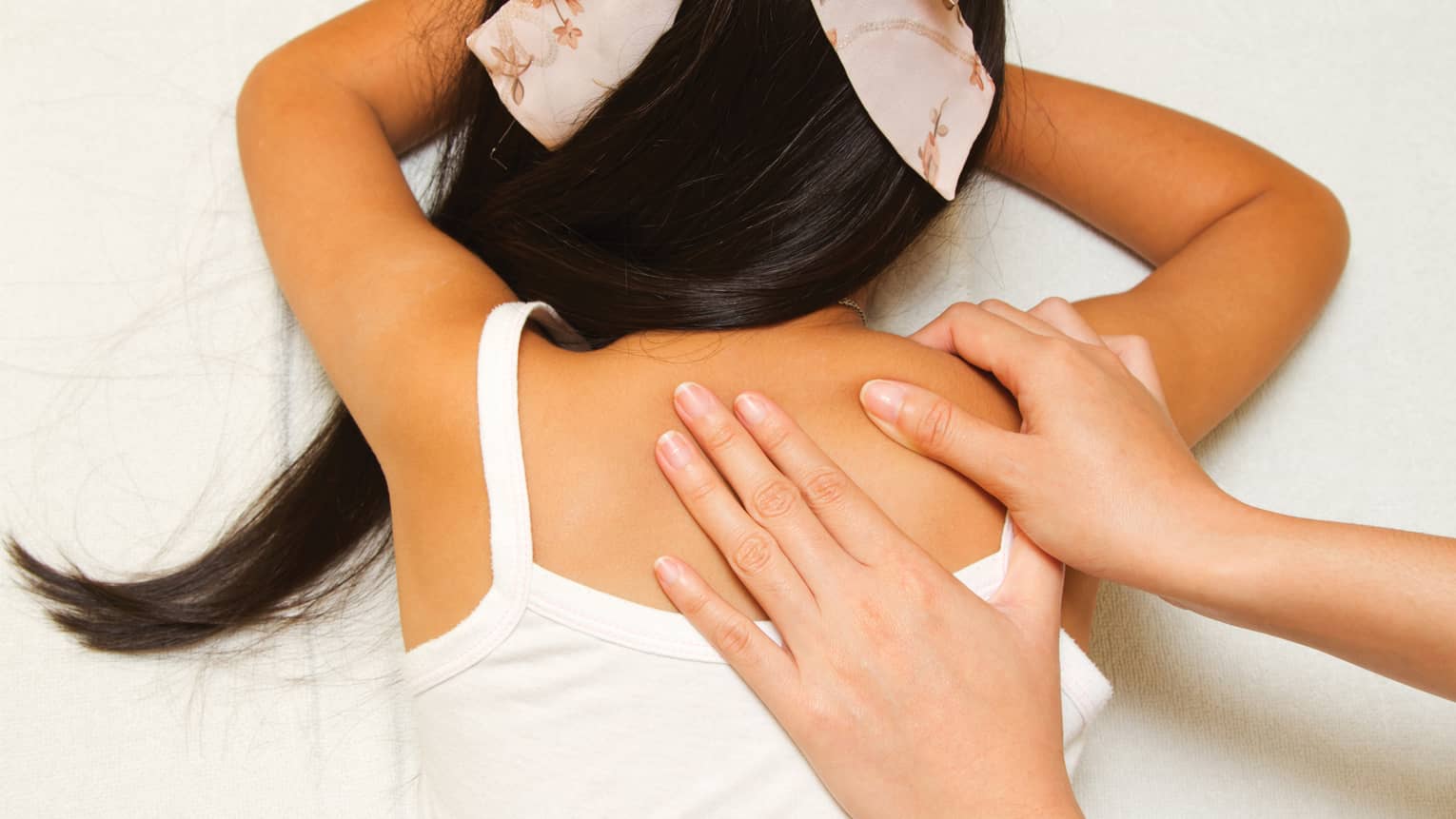 Masseuse hands massage girl's shoulders
