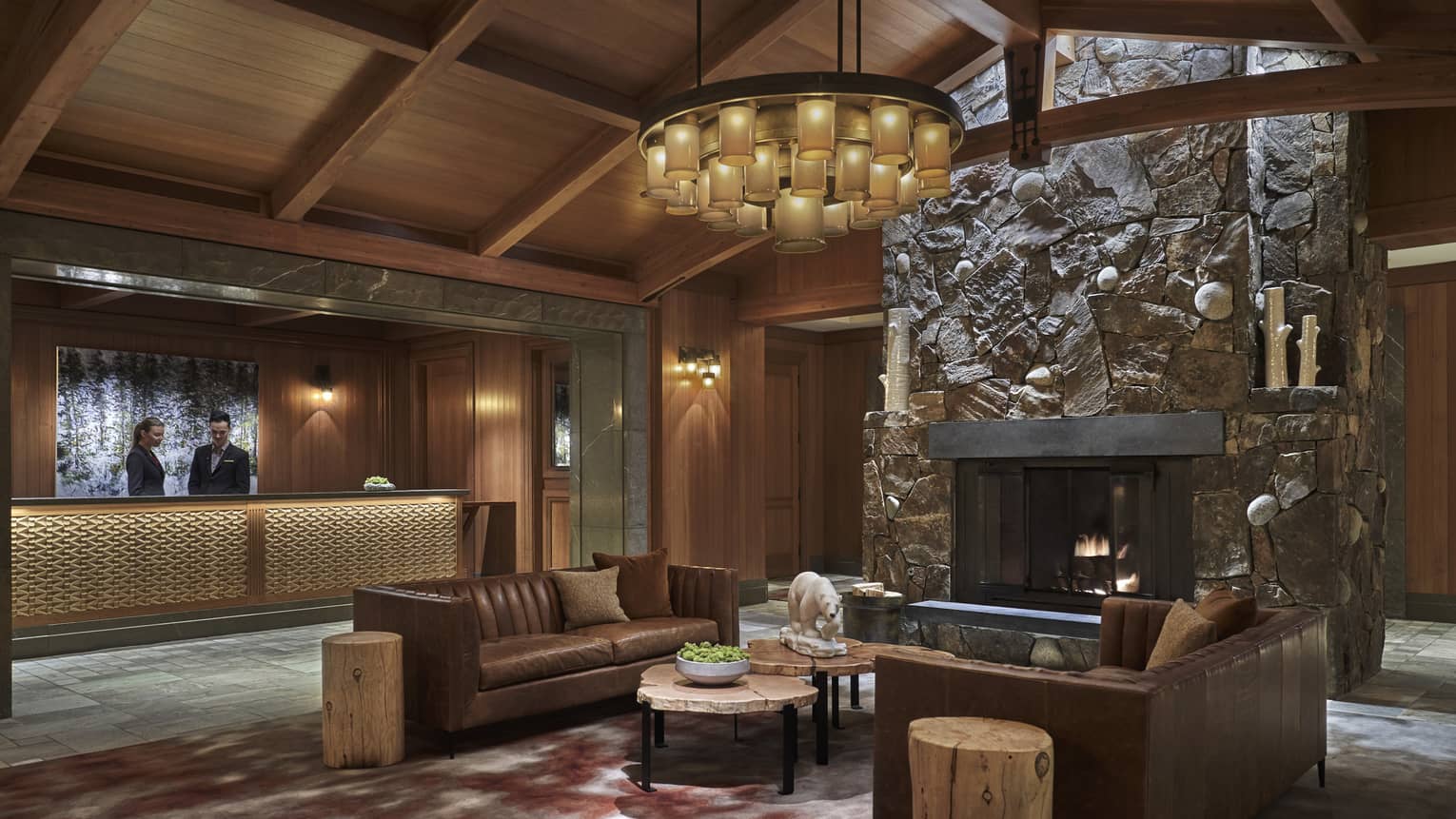 The lobby paneled with dark wood, with a couch in the centre of the room.