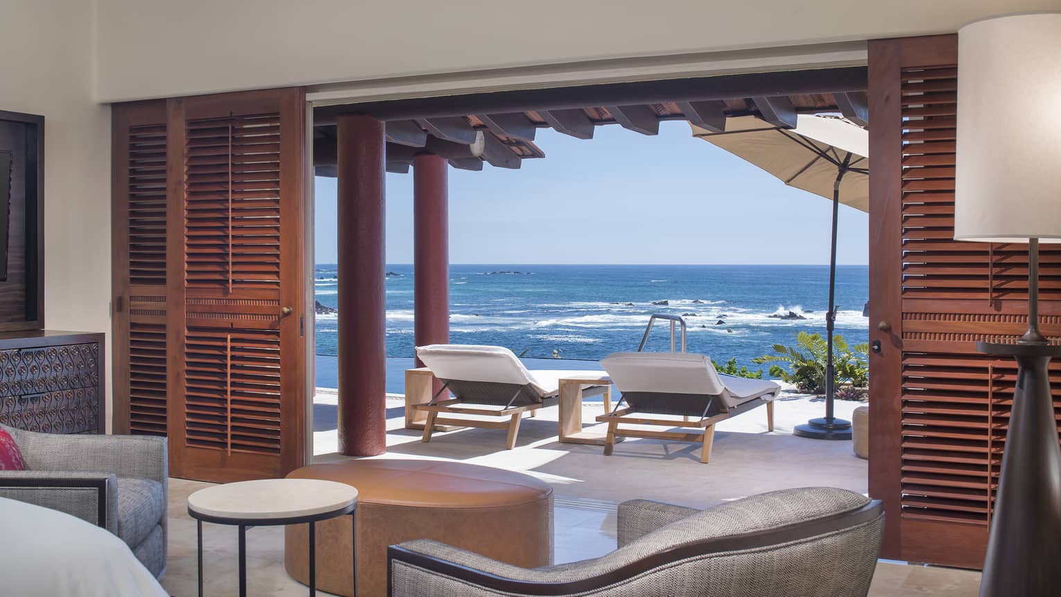 Interior photo of the 5 Bedroom Villa in Mexico, Sol. Lounge area with comfortable seating opening onto an ocean view terrace with sun loungers.