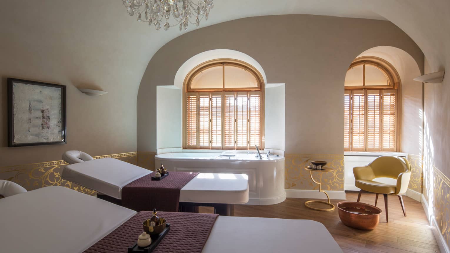 Two white beds beside spa tub in dimly-lit room at the Vltava Suite at AVA Spa