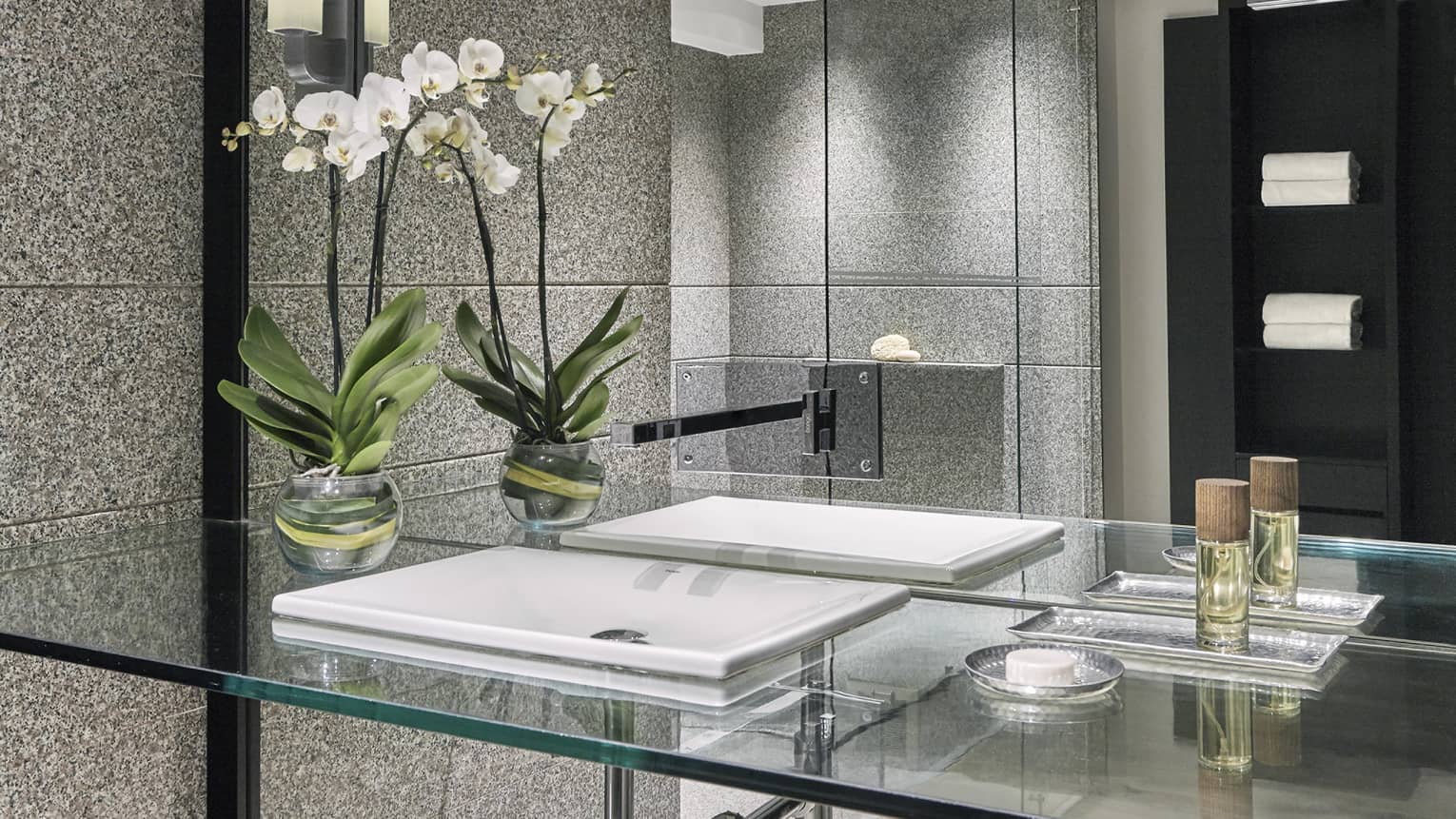 Marble bathroom with a glass vanity and glass-enclosed shower