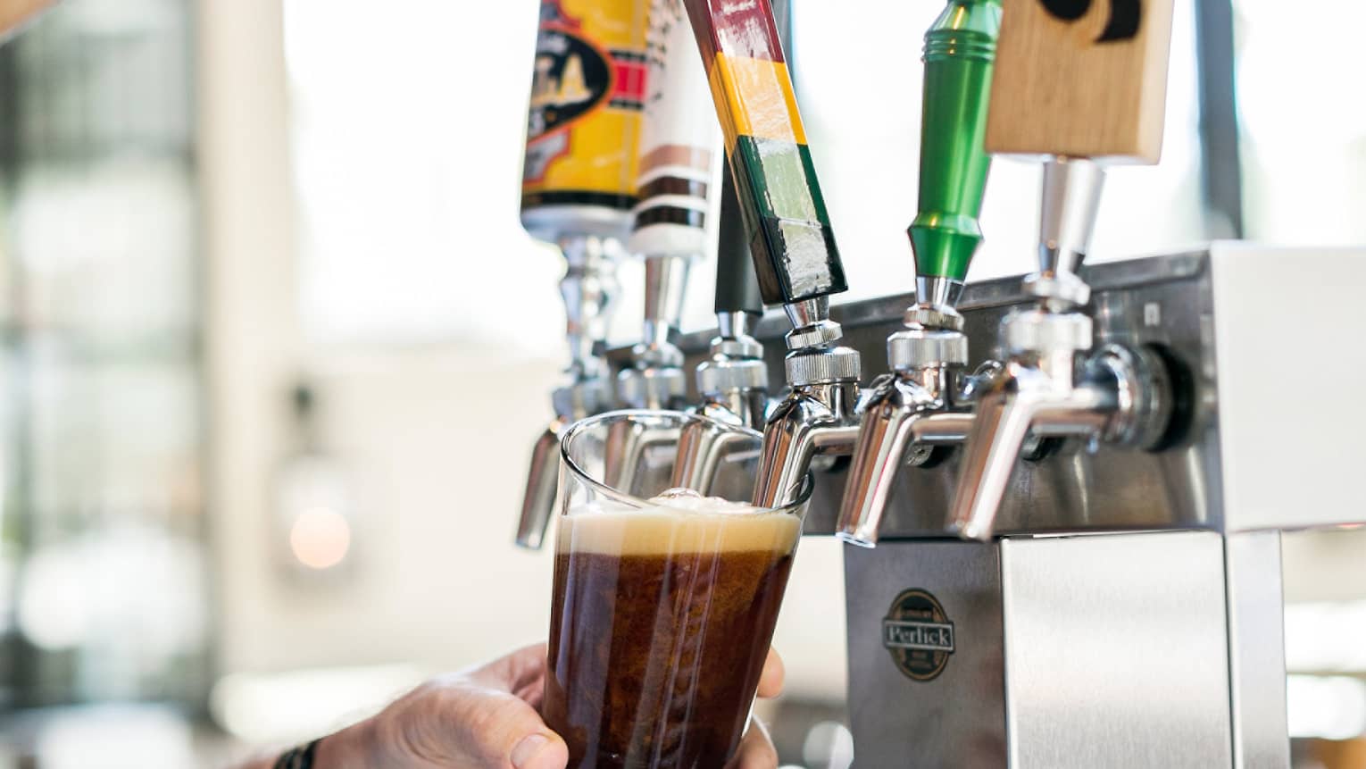 A draft beer being poured into a glass.