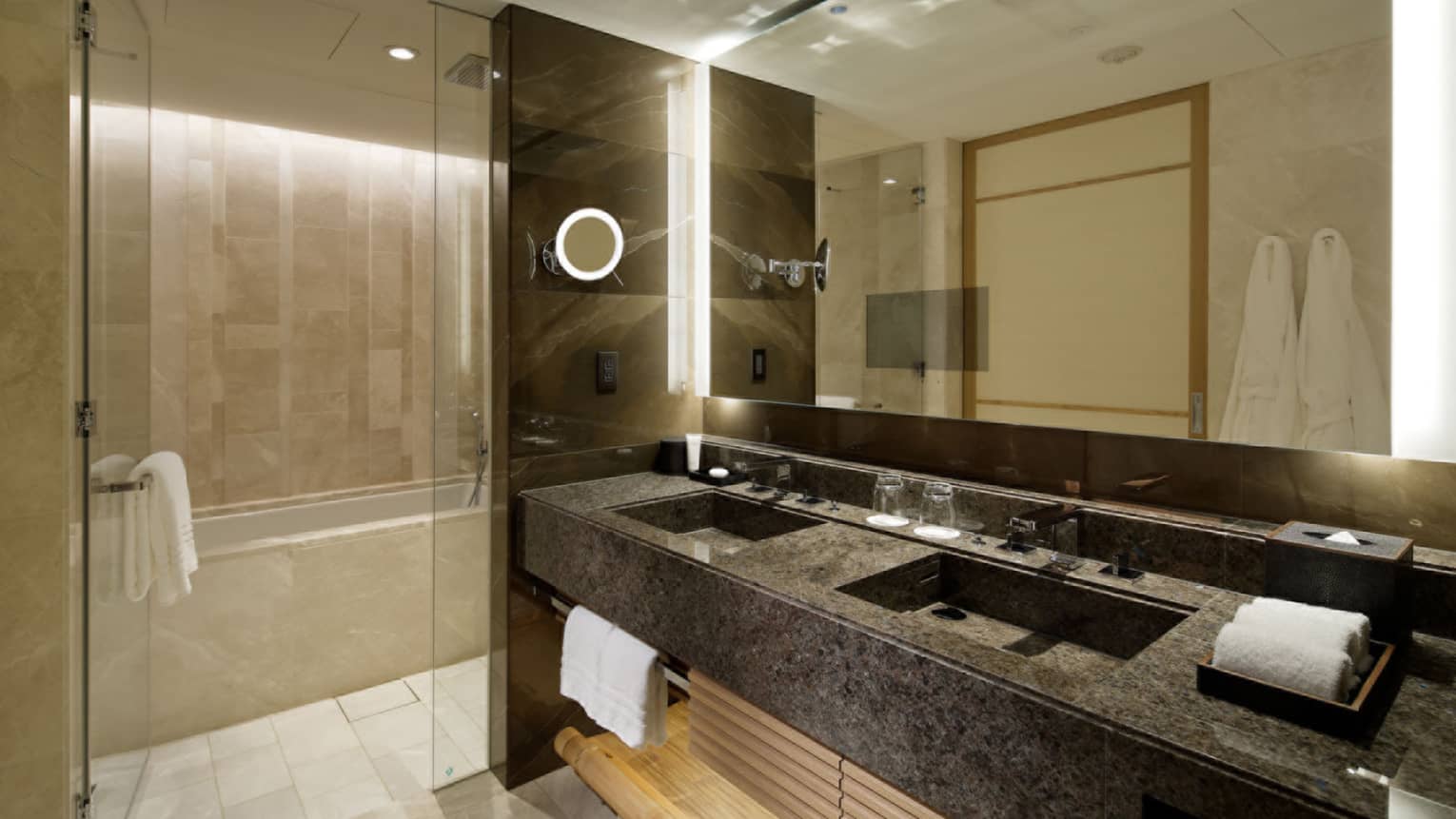 Bathroom with dark marble double vanity, walk-in shower and deep soaking tub