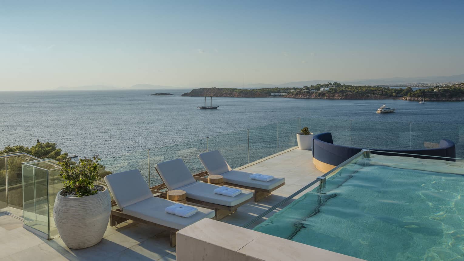 Arion Presidential Suite rooftoop with plunge pool, lounge chairs, boats on the Mediterranean in the background