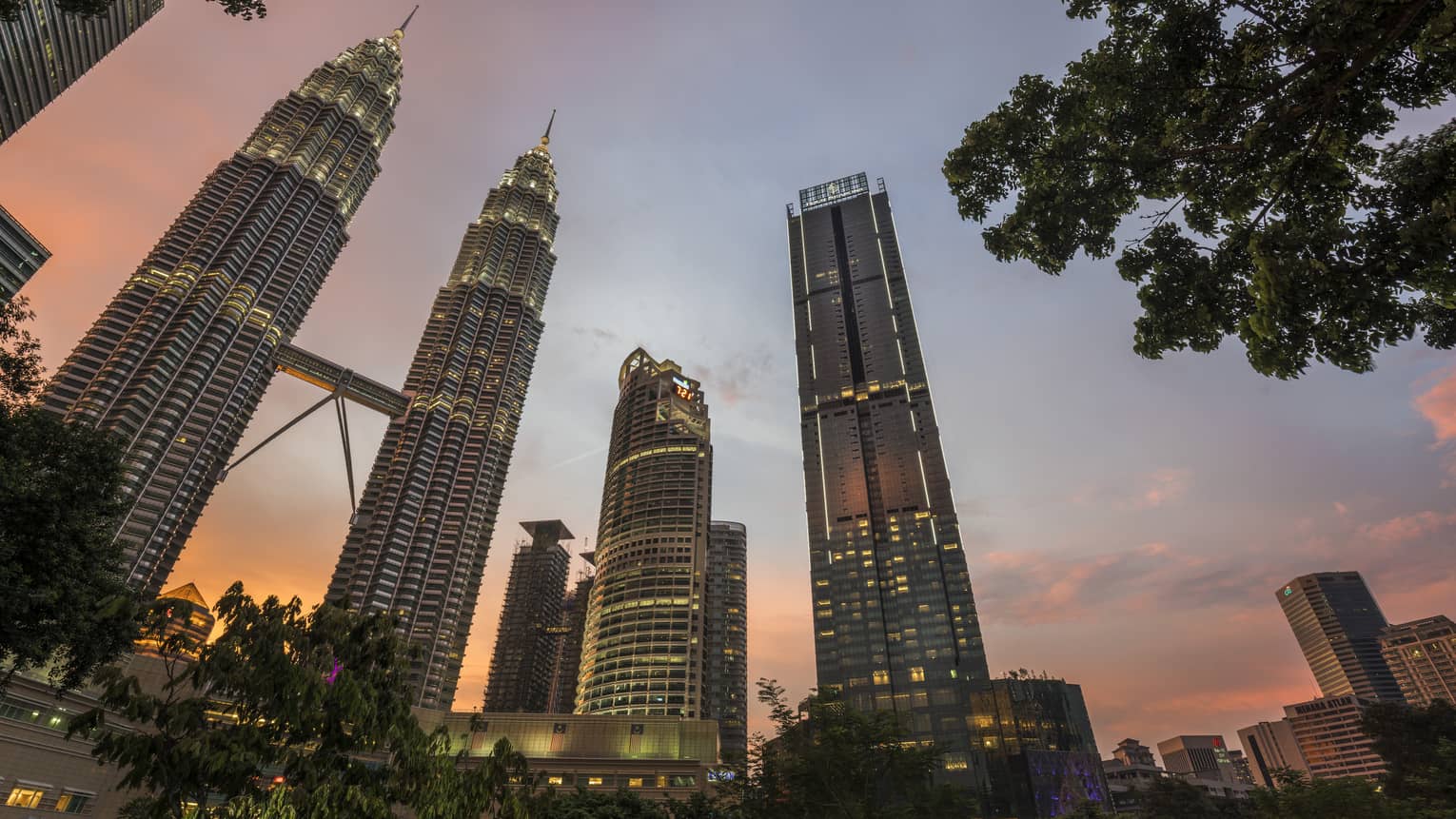 Four Seasons Hotel Kuala Lumpur against the sunset with the city skyline
