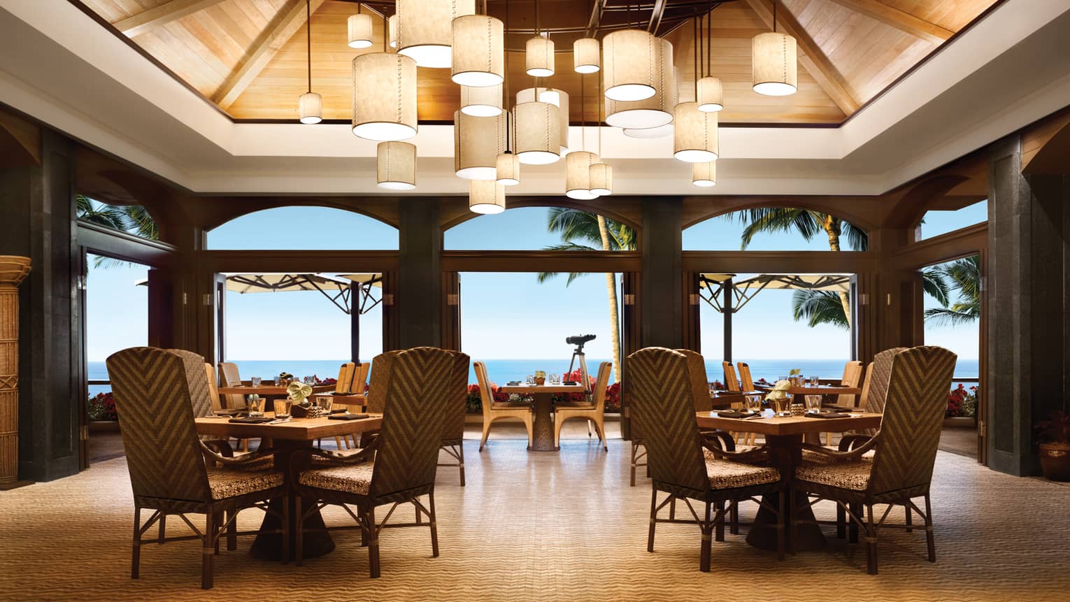 Views Restaurant dining room, tables and chairs under vaulted ceilings with modern lanterns
